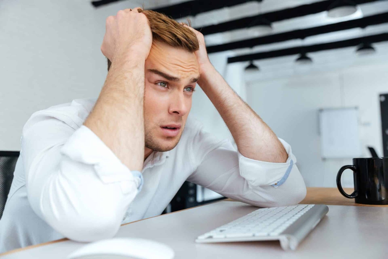 Upset disappointed young businessman sitting with hands on head Slow Internet